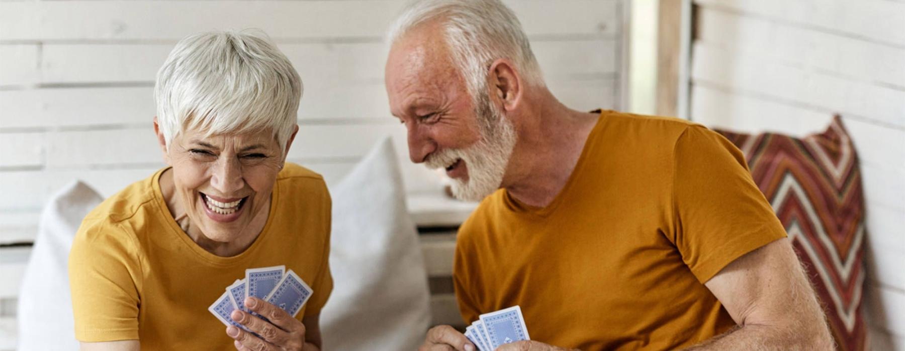 a man and woman sitting at a table playing cards